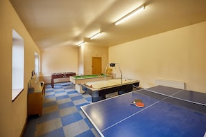 Ein Raum mit Billardtisch, Kicker und Tischtennis.