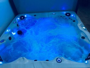 A hot tub with a blue-lit interior, surrounded by a tiled floor. - 🌟Luxury Villa Mimosa - Large 4 bedroom Villa with Air Con Hot Tub Heated Pool🌟 (Antigua)