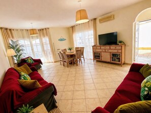 A living room with a sofa set, a dining table with chairs, a television, and a cabinet. - 🌟Luxury Villa Mimosa - Large 4 bedroom Villa with Air Con Hot Tub Heated Pool🌟 (Antigua)