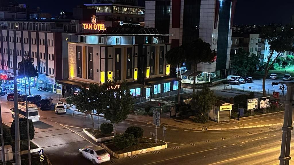 Un hotel con un letrero llamativo, varios pisos y un área de estacionamiento.