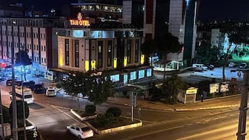 Un hotel con un letrero llamativo, varios pisos y un área de estacionamiento.