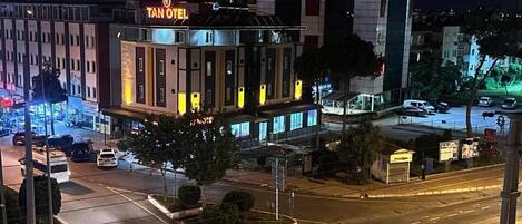 A hotel with a prominent sign, multiple floors, and a parking area.