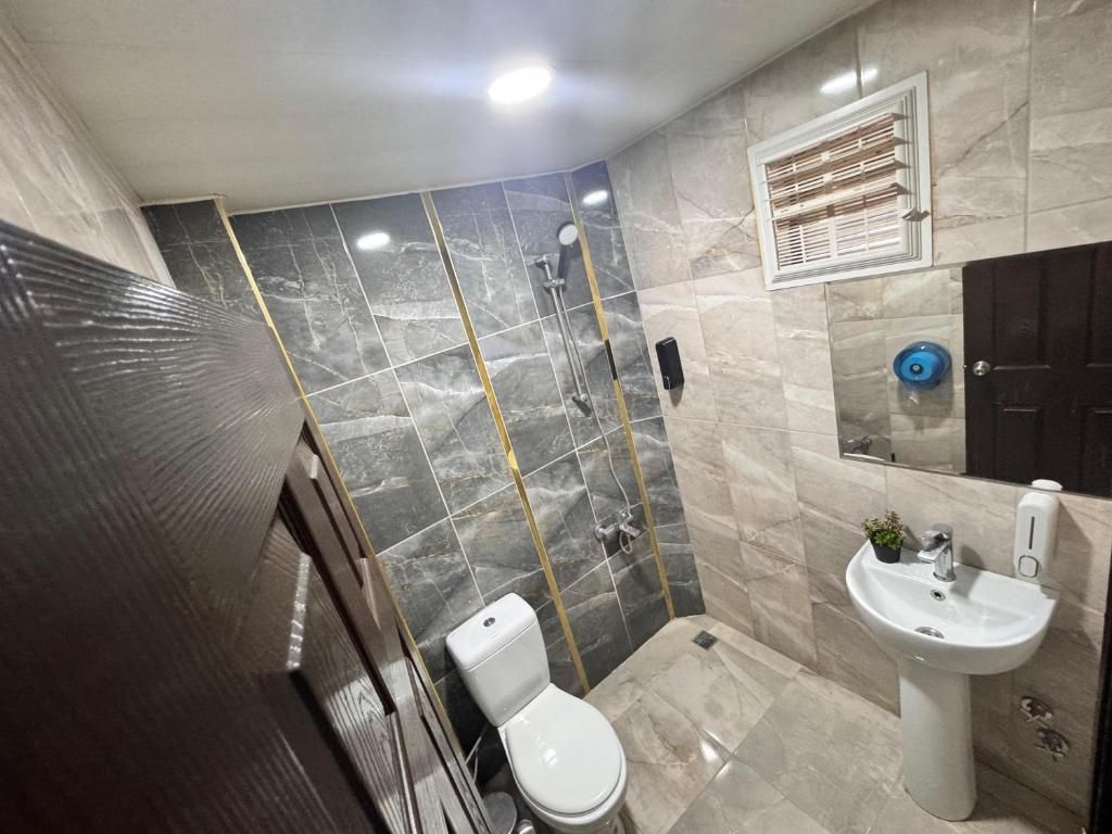 Un baño con inodoro, ducha y lavamanos.