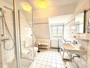 A modern bathroom with a glass shower enclosure, a white sink, and a toilet. - Island Bliss Fohr (Wrixum)