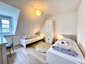 A modern bedroom with a loft bed, a desk, and a wardrobe. - Island Bliss Fohr (Wrixum)