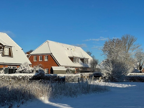 A residential area with houses featuring pitched roofs and brick exteriors. - Island Bliss Fohr (Wrixum)