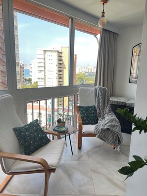 A balcony with two chairs, a small table with a book, and a potted plant. - New Listing (Benidorm)