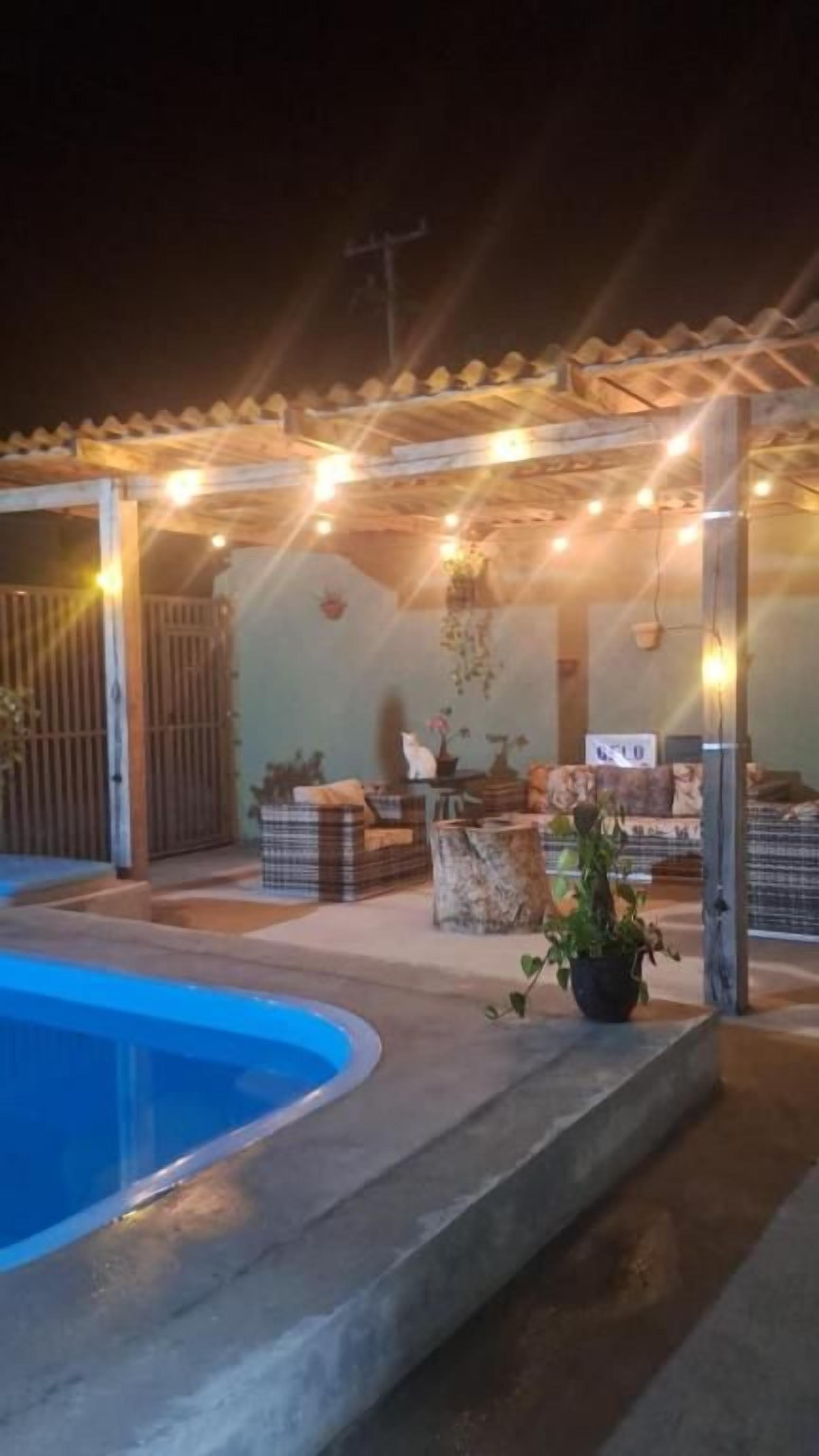 Ein überdachter Außenbereich mit Pool, Sitzgelegenheiten und Lichterketten.
