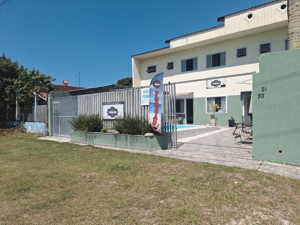 A building with a gated entrance, a signboard, and a clear sky.