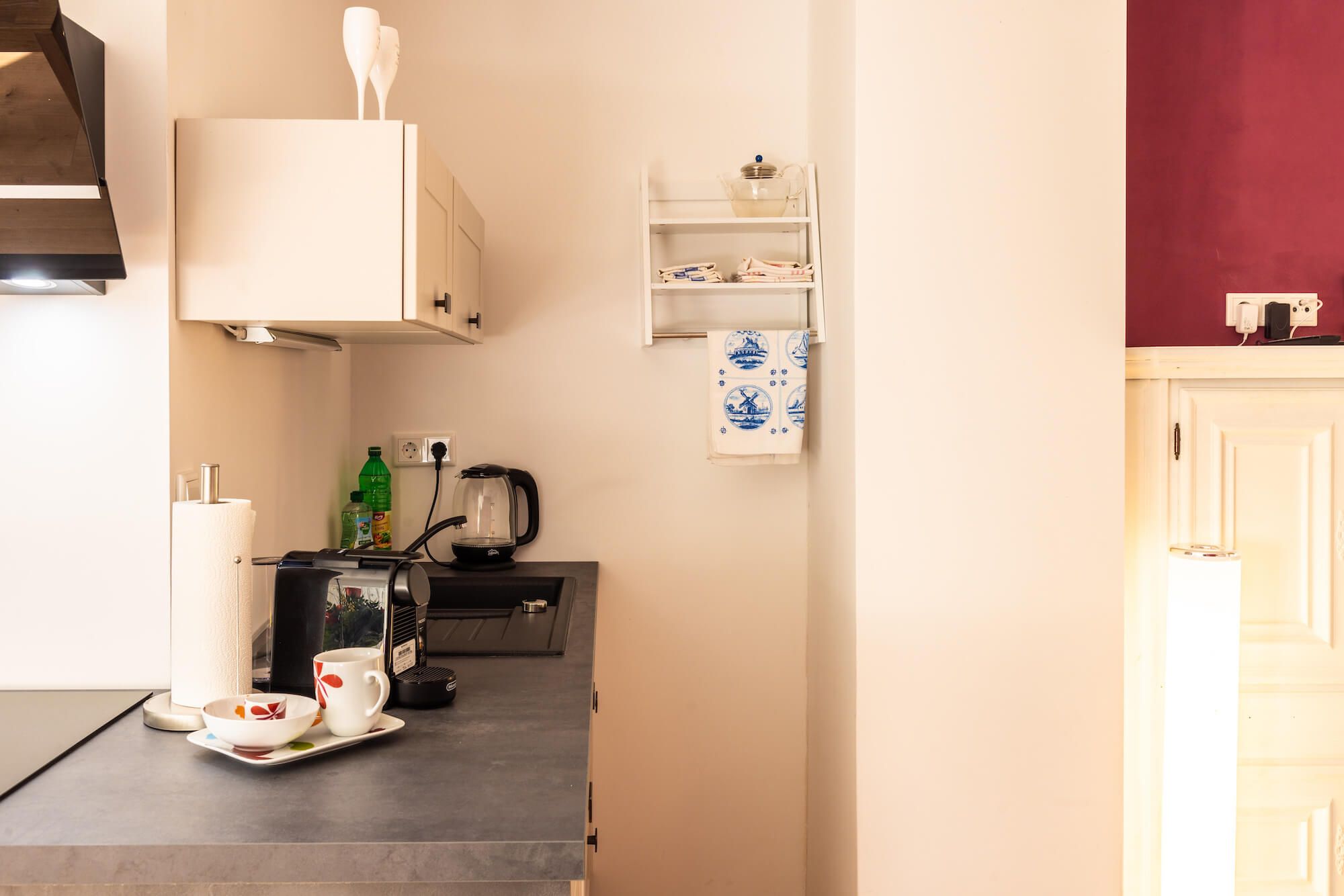 Eine Küchenzeile mit Kaffeemaschine, Wasserkocher und Teekocher auf der Arbeitsfläche.