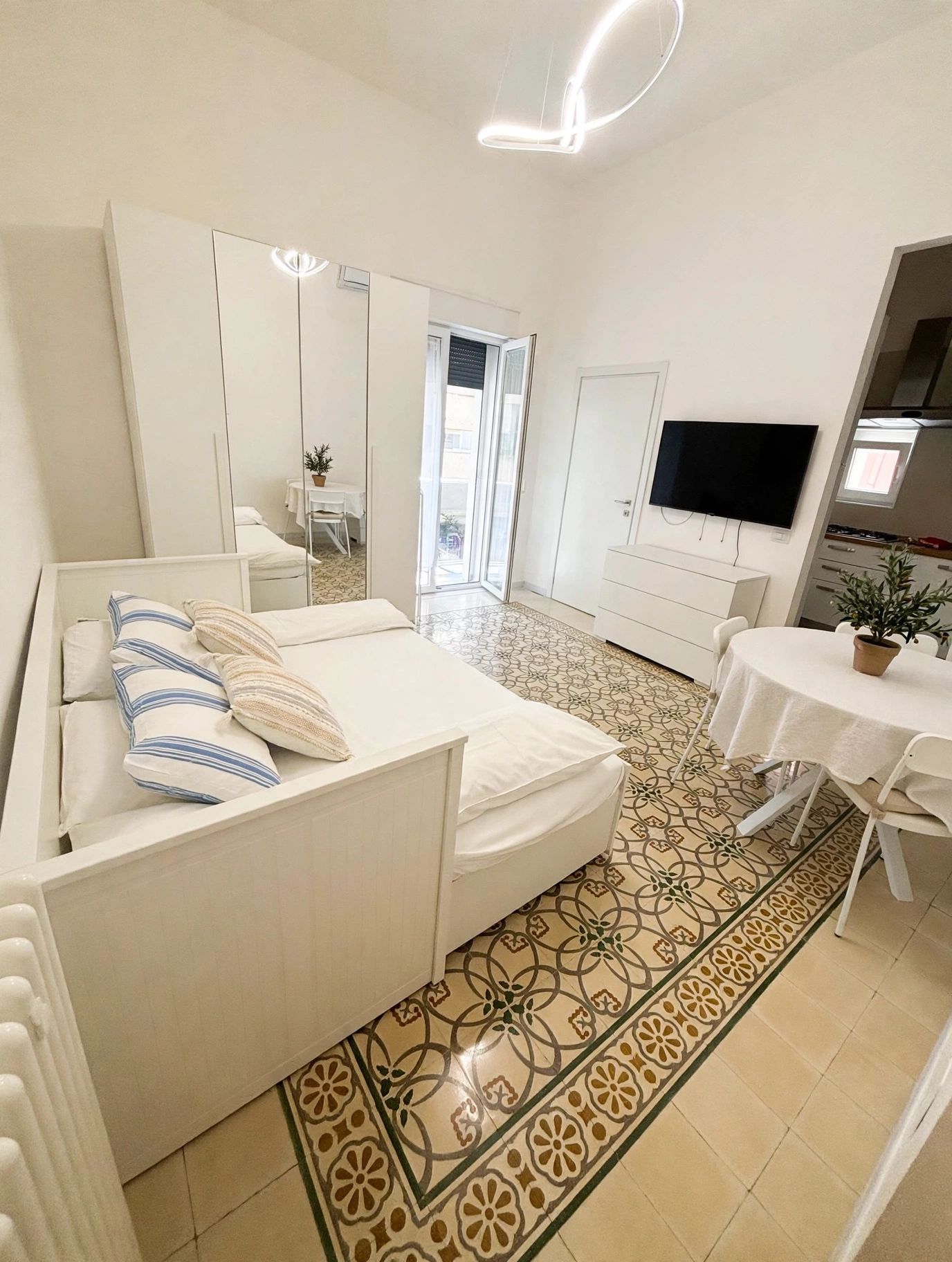Una camera da letto moderna con un letto, una televisione, un tavolino e un bagno.