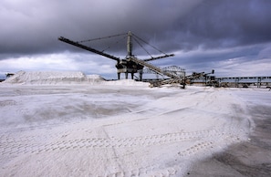 Een uitgebreide industriële mijnbouwactiviteit met zware machines en een transportband systeem.