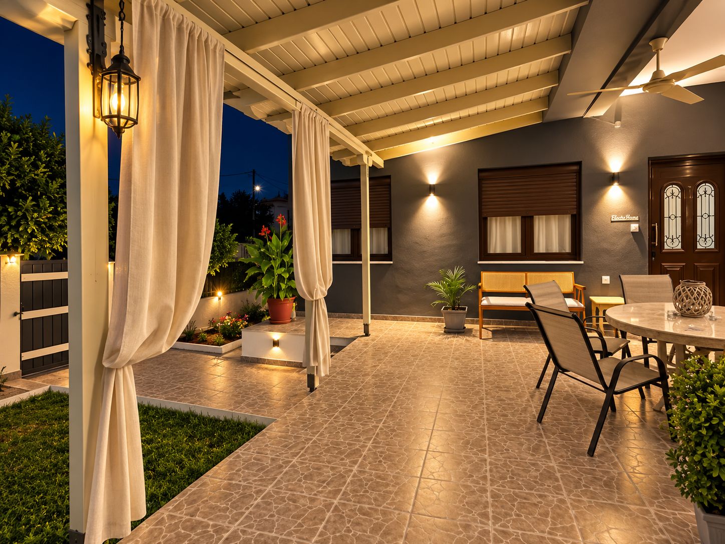 Un espace extérieur aménagé en patio, avec un coin salon couvert, une table et des plantes en pot.