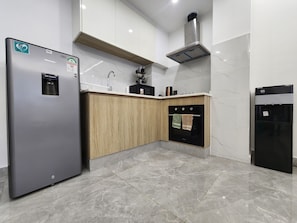A modern kitchen with a stainless steel refrigerator, wooden cabinets, a built-in oven, and a water dispenser. - Cozy 1-bedroom apartment in awesome Nairobi with gym and pool- Kilimani (Nairobi)