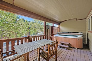 A wooden deck with a table and chairs, a hot tub, and a view of trees and buildings. - Bear Hollow Beauty. Hottub Walk To Free Bus 5435 5 Bedroom Home (Park City)
