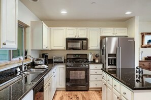 A modern kitchen with white cabinets, stainless steel appliances, and a granite countertop. - Bear Hollow Beauty. Hottub Walk To Free Bus 5435 5 Bedroom Home (Park City)