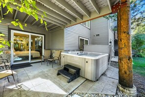 A patio with a hot tub, outdoor seating, and a sliding glass door leading to a bedroom. - Deer Valley Ski Retreat Hot Tub & Fire Pit 1111 2 Bedroom Home (Park City)