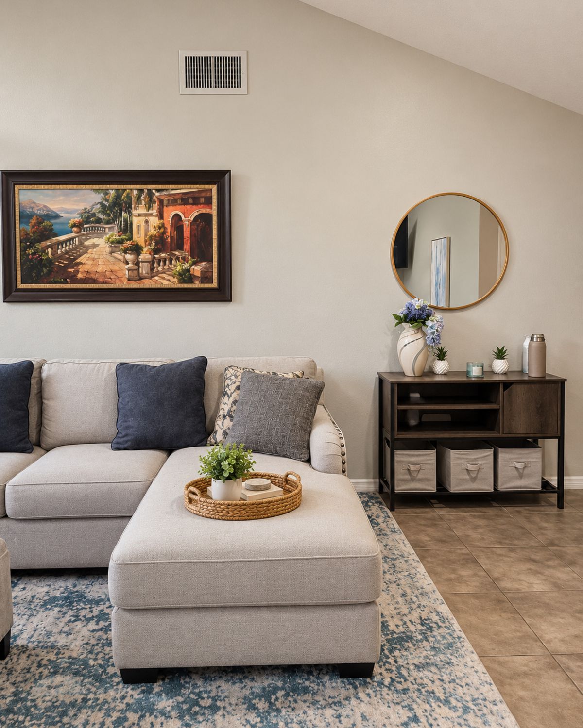 A living room with a sofa, ottoman, and a side table with decorative items.