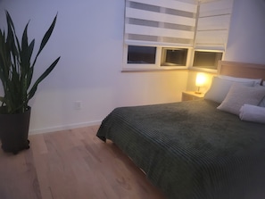 Ein Schlafzimmer mit einem Bett, einer Nachttischlampe und einer Topfpflanze.