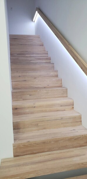 A wooden staircase with a white wall and a wooden handrail. - Walk Kingsville !! 2 to 7 minute walk to all the great spots ! 8 People (Kingsville)