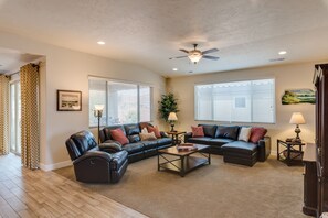A living room with a sectional sofa, a coffee table, and a ceiling fan. - Canyonlands #1 3 Bedroom Home (Ivins)