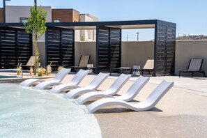 A pool area with lounge chairs and a covered seating area. - The Desert Isle 5 Bedroom Townhouse (Washington)
