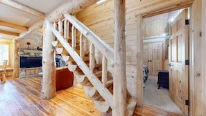 A wooden interior with a staircase, a stone fireplace, and a television. - Sierra Megeve #29 3 Bedroom Condo (Mammoth Lakes)