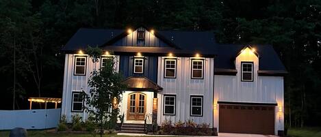 A two-story house with a front porch, a garage, and a well-maintained lawn.