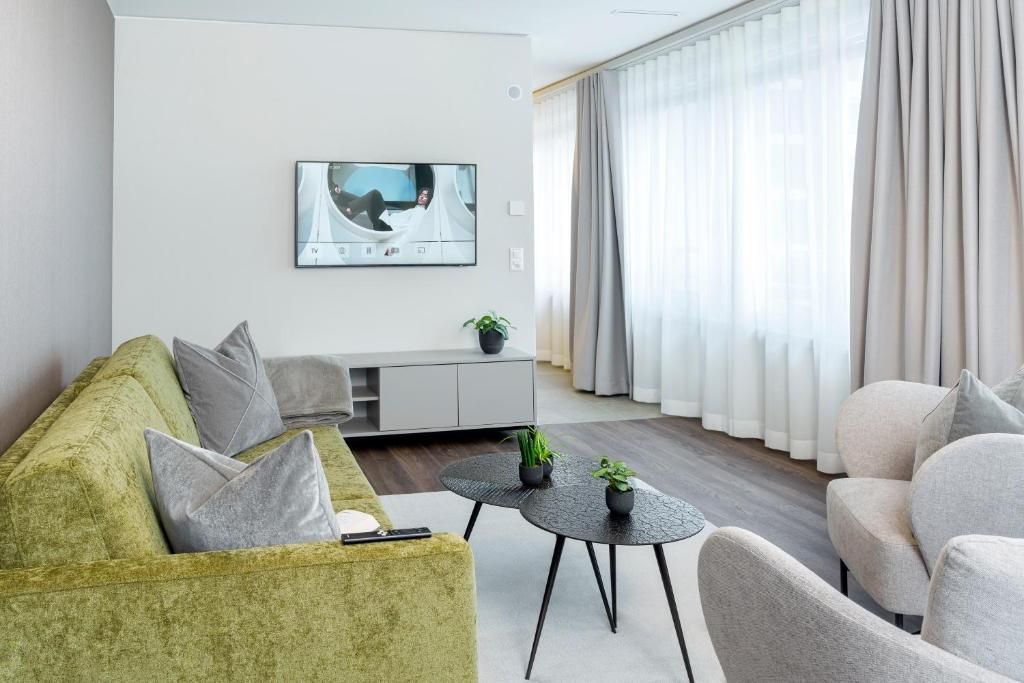 A modern living room with a sofa, armchair, and a coffee table.