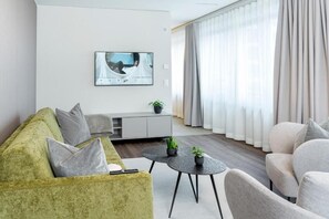Una sala moderna con sofá, sillón y mesa de centro.