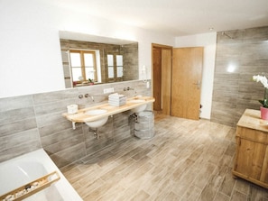 A modern bathroom with a double sink, a large mirror, and a wooden cabinet. - Luna Mia Apartment 3 (Schwangau)