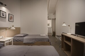 A hotel room with two beds, a desk with a lamp, a TV, and a wardrobe. - New Listing (Krnica)