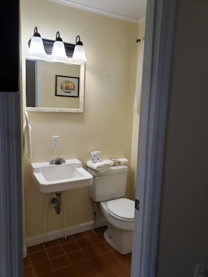 Un baño con lavamanos, inodoro y un espejo con iluminación.