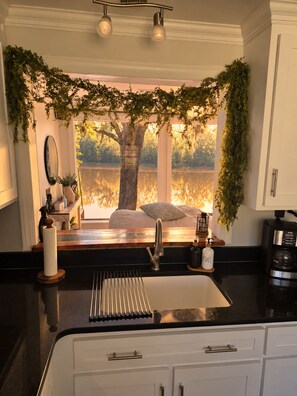 A kitchen with a large window, a sink, and a coffee maker. - Riverview w/Dock/Sleeps 4 (Uvalda)