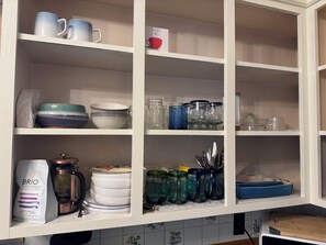 A kitchen with white cabinets, a coffee maker, and various dishes and jars. - Functional 3-bedroom apartment in delightful Montpelier perfect for families (Montpelier)