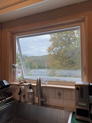 Eine Küche mit Fenster, einer Edelstahl-Spüle und einem Toaster.