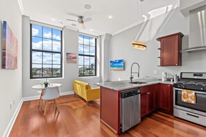 Una cocina moderna con una isla central, electrodomésticos de acero inoxidable y amplios ventanales con vistas a la ciudad.