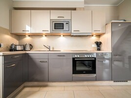 Una cocina moderna con horno empotrado, microondas y electrodomésticos de acero inoxidable.