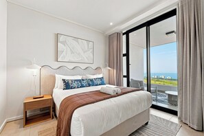 Ein modernes Hotelzimmer mit einem großen Bett, Blick auf die Stadt und einem Balkon.