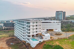 A multi-story hotel with a rooftop pool and a view of the surrounding area. - Stylish Umhlanga 2Bed | Aircon and Gym (Umhlanga)