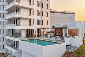 A modern hotel with a rooftop pool, multiple balconies, and a sign that reads 'YORK'. - Umhlanga 2BR | Aircon, Balcony and Gym (Umhlanga)