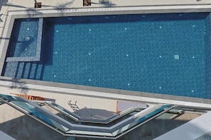 Una piscina con borde de azulejos y zona de visibilidad de cristal.