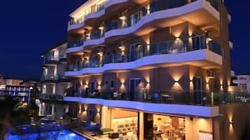Un hotel de varios pisos con piscina, zona de estar al aire libre y bar.