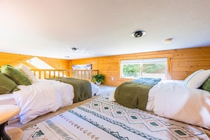 Quarto com duas camas, uma janela e um ventilador de teto.