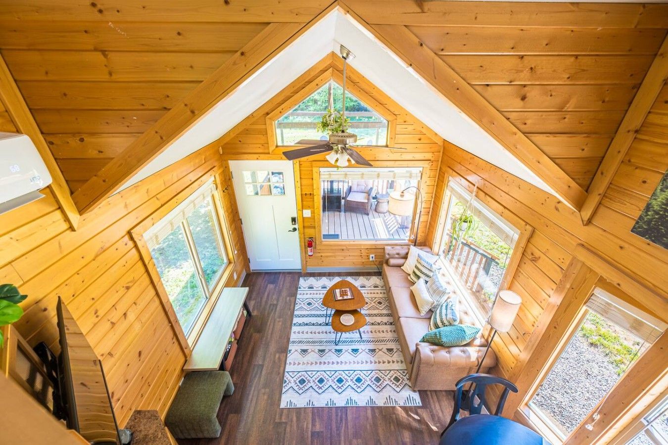 Una cabaña de madera con un entrepiso, un comedor y vistas al exterior.