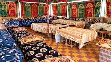 A traditional inn with multiple rooms, each with a distinct patterned bedspread and a checkered floor.