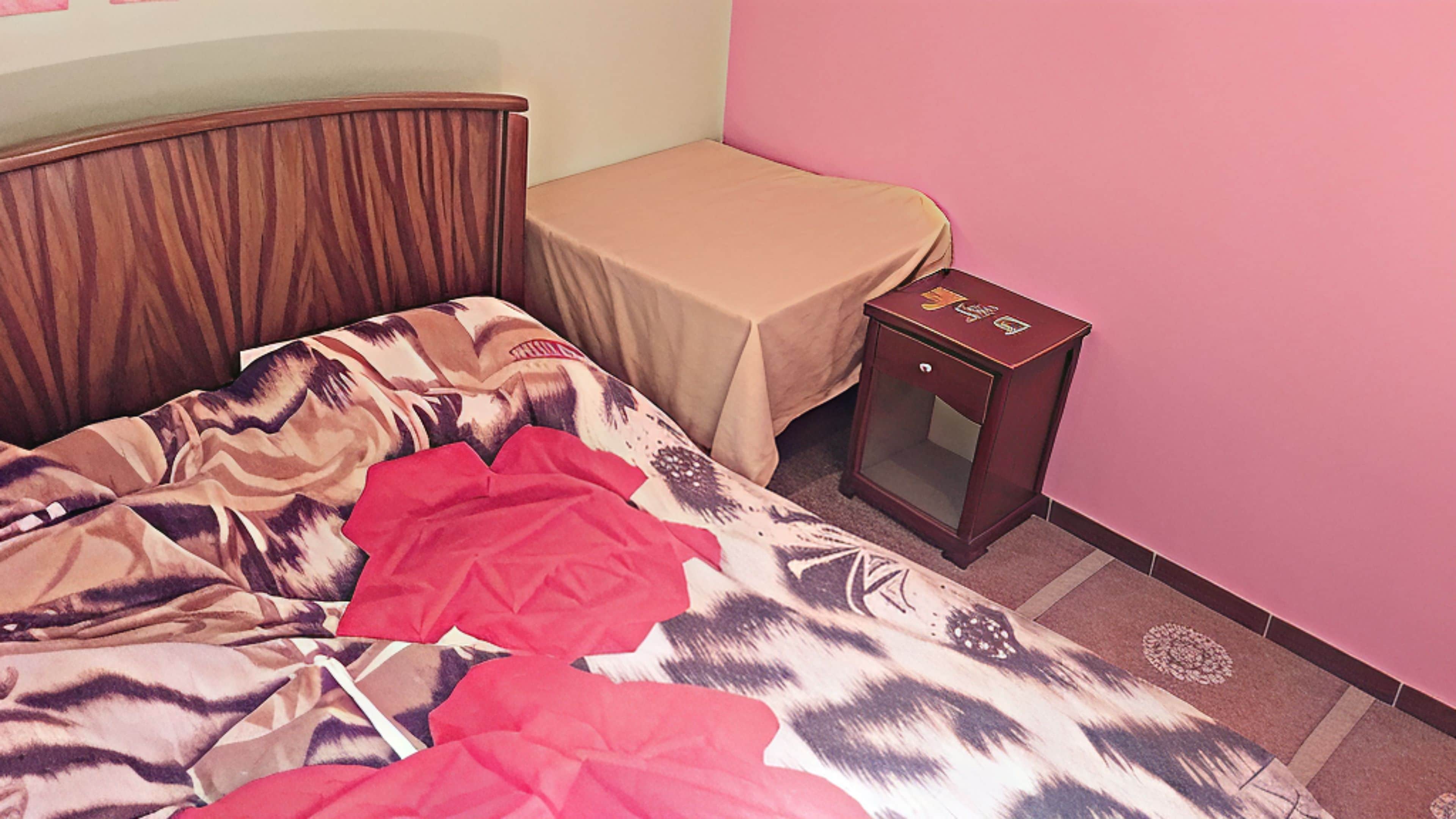 A bedroom with a bed, a bedside table, and a nightstand.