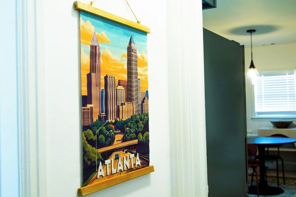 A framed cityscape poster of Atlanta on a wall.