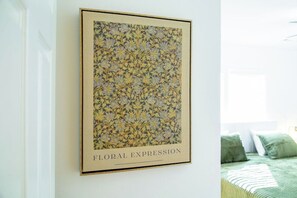 Una obra d'art floral emmarcada, titulada 'FLORAL EXPRESSION', penjada a la paret.