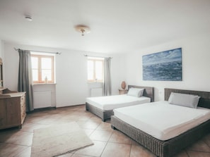 A hotel room with two beds, a large window, a painting, and a radiator. - Luna Mia Apartment 2 (Schwangau)